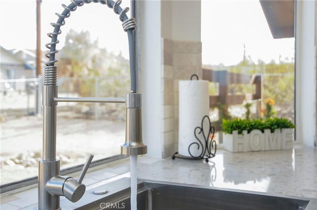 details featuring light stone countertops and sink