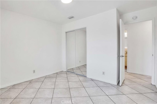 unfurnished bedroom featuring light tile patterned floors and a closet