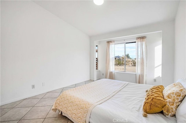 bedroom featuring light tile patterned floors and vaulted ceiling