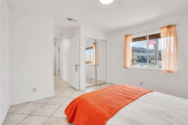 bedroom featuring light tile patterned floors and a closet