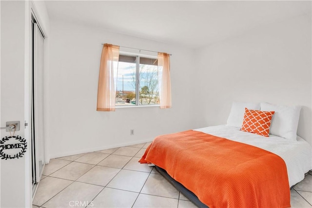 tiled bedroom with a closet