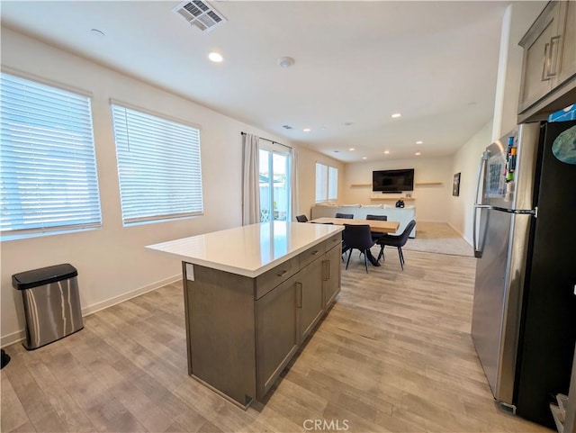 kitchen featuring a kitchen island, light hardwood / wood-style floors, and stainless steel fridge