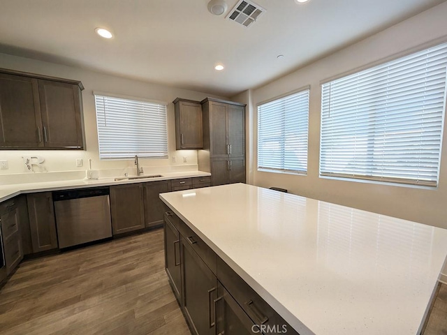 kitchen featuring sink, dark brown cabinetry, stainless steel dishwasher, and dark hardwood / wood-style floors