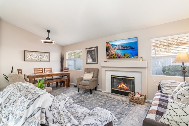 living room with lofted ceiling and a tiled fireplace