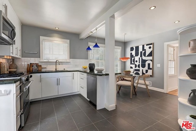 kitchen with stainless steel appliances, white cabinets, hanging light fixtures, and sink