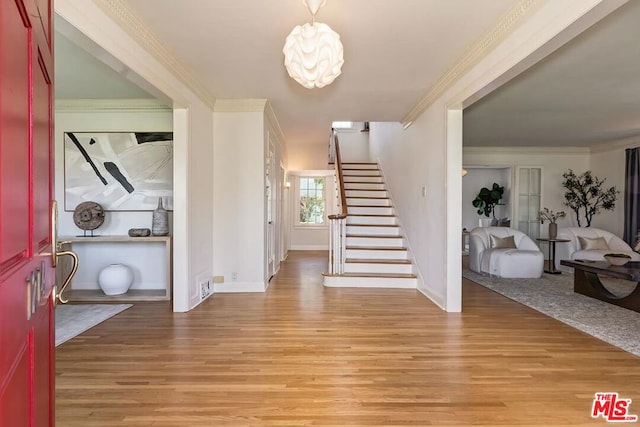 foyer featuring light hardwood / wood-style floors and crown molding