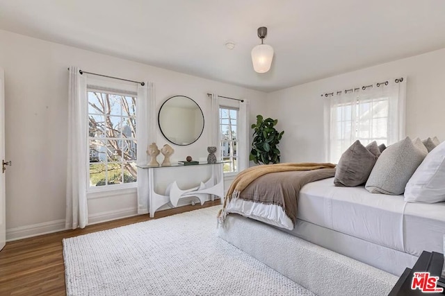 bedroom with dark wood-type flooring and multiple windows