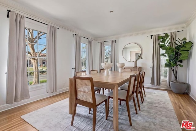 dining room with ornamental molding and light wood-type flooring