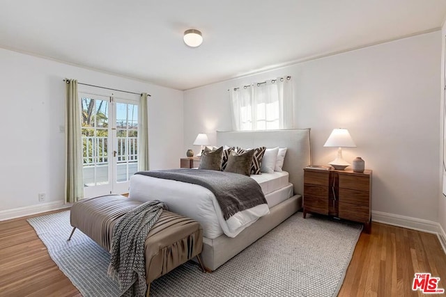 bedroom featuring french doors, hardwood / wood-style flooring, and access to outside