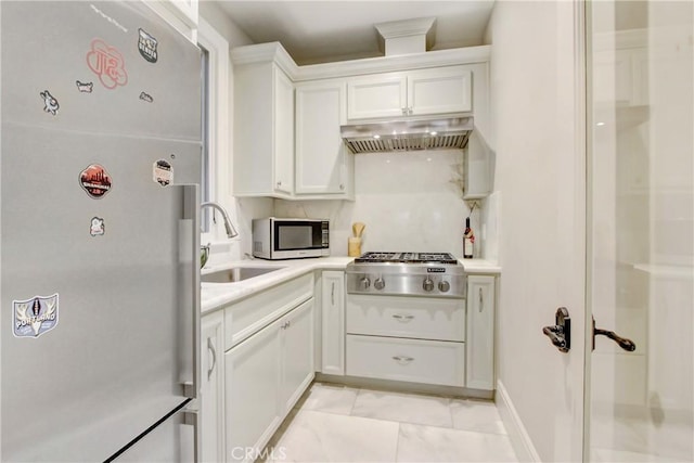 kitchen featuring backsplash, extractor fan, sink, stainless steel appliances, and white cabinets