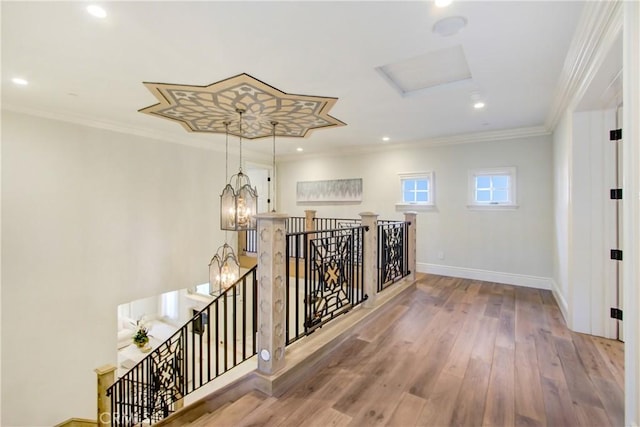 hallway featuring a chandelier, crown molding, and hardwood / wood-style flooring