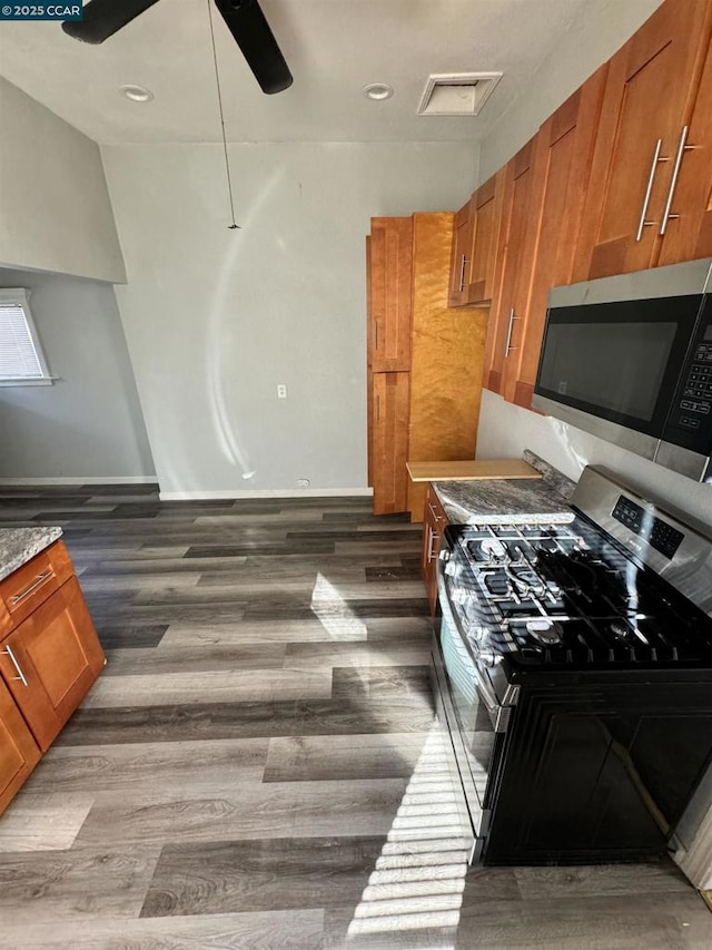 kitchen with ceiling fan, dark wood-type flooring, and appliances with stainless steel finishes