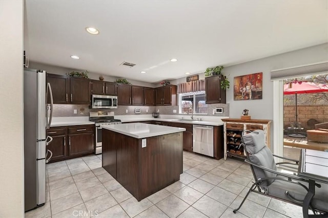 kitchen with dark brown cabinetry, a wealth of natural light, stainless steel appliances, and a center island