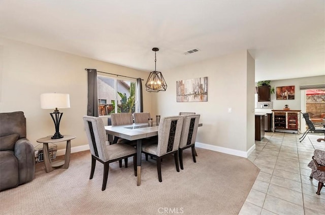 dining space with light tile patterned flooring and a chandelier