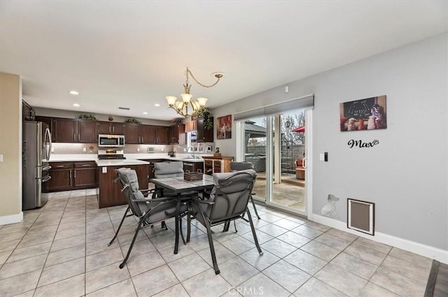 dining space with an inviting chandelier, sink, and light tile patterned flooring