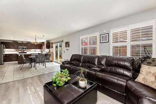 living room with a notable chandelier and light hardwood / wood-style flooring