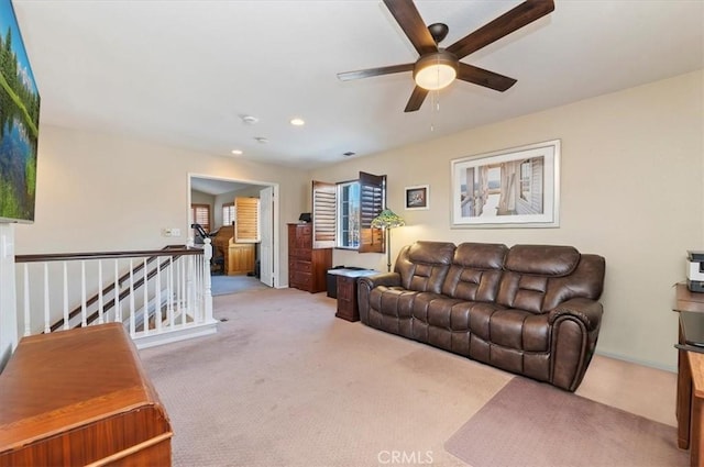 carpeted living room with ceiling fan