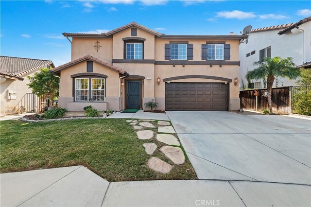 mediterranean / spanish house featuring a garage and a front lawn