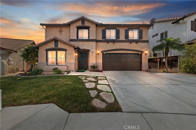 view of front of home with a garage and a yard