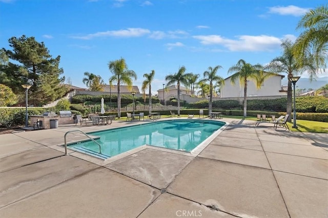 view of swimming pool with an outdoor kitchen and a patio