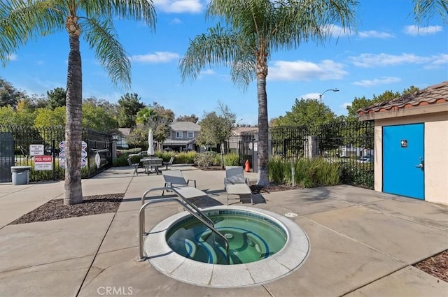 view of swimming pool featuring a community hot tub and a patio area