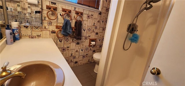 bathroom with a shower, sink, toilet, and tile patterned flooring