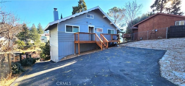 rear view of house featuring a wooden deck