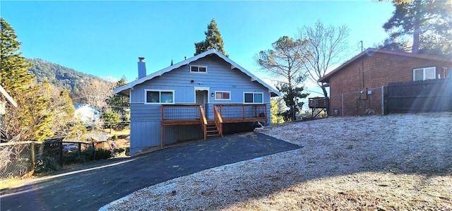 rear view of property with a deck with mountain view