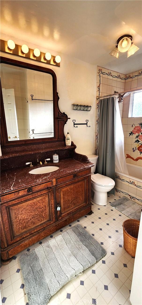 full bathroom with toilet, vanity, and shower / bath combo with shower curtain