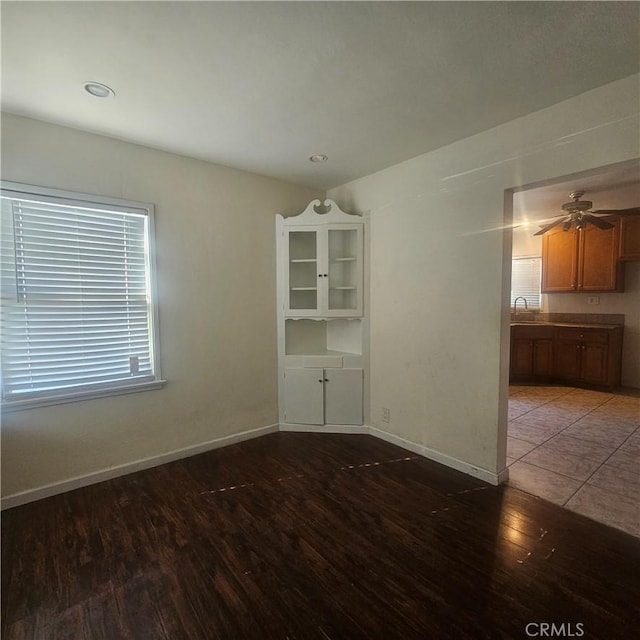 empty room featuring ceiling fan, sink, and wood-type flooring