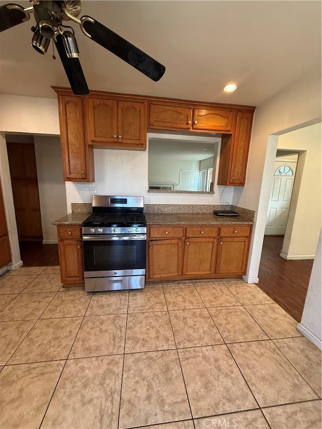 kitchen featuring gas range, light tile patterned floors, and ceiling fan