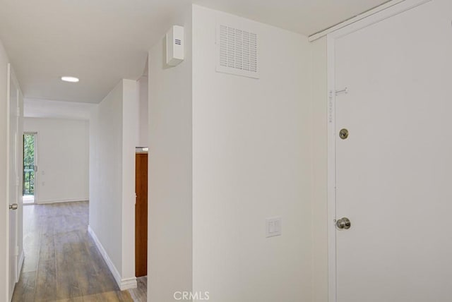 hallway with wood finished floors and baseboards