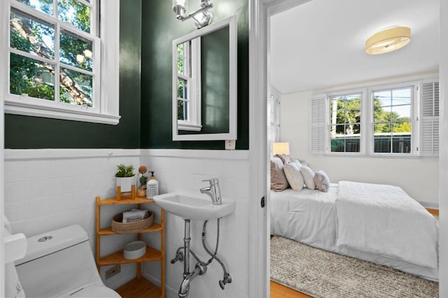 bedroom featuring multiple windows, wood-type flooring, and sink