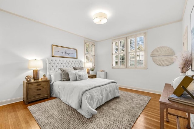 bedroom featuring wood-type flooring and ornamental molding