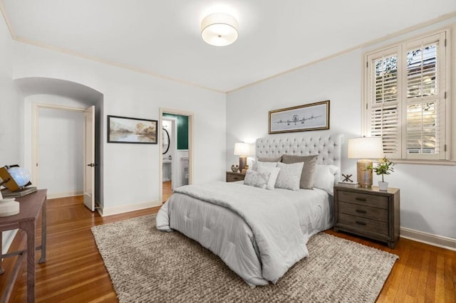 bedroom featuring hardwood / wood-style flooring, crown molding, and ensuite bathroom