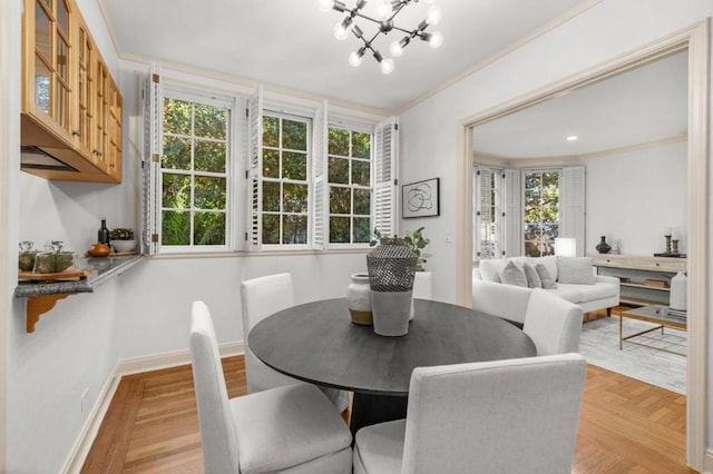 dining space with an inviting chandelier, a healthy amount of sunlight, ornamental molding, and light parquet floors