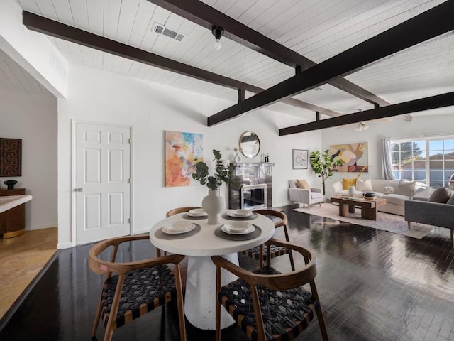 dining space featuring hardwood / wood-style floors, vaulted ceiling with beams, and wood ceiling