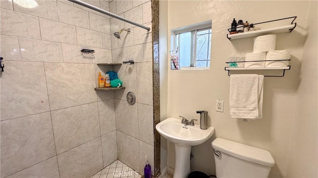 bathroom with toilet and a tile shower