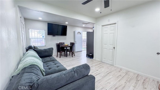 living room with ceiling fan and light hardwood / wood-style flooring