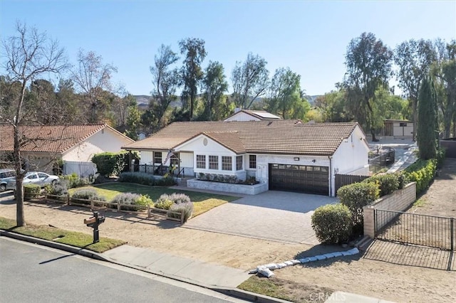ranch-style home with covered porch, decorative driveway, a tiled roof, an attached garage, and fence