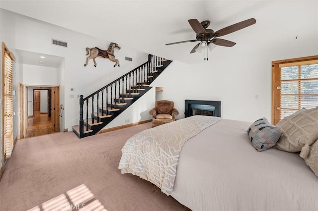 bedroom with carpet flooring, visible vents, baseboards, and a fireplace
