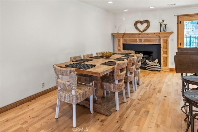 dining room with a fireplace, light wood-style floors, recessed lighting, and baseboards