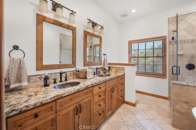 bathroom featuring baseboards, visible vents, a stall shower, and a sink
