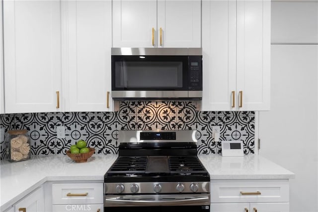 kitchen featuring white cabinets, backsplash, appliances with stainless steel finishes, and light stone counters