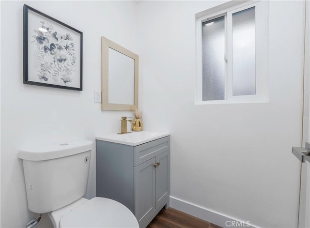 bathroom with wood-type flooring, toilet, and vanity