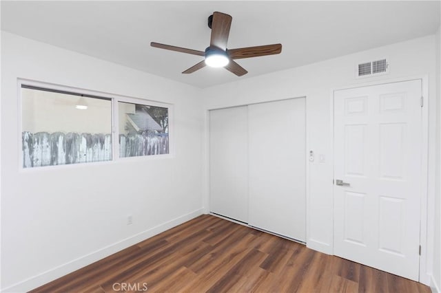 unfurnished bedroom featuring ceiling fan and dark hardwood / wood-style floors