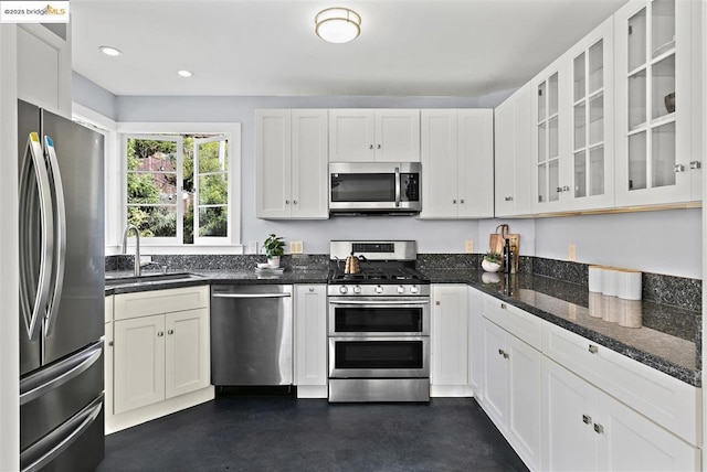 kitchen featuring sink, white cabinetry, appliances with stainless steel finishes, and dark stone counters