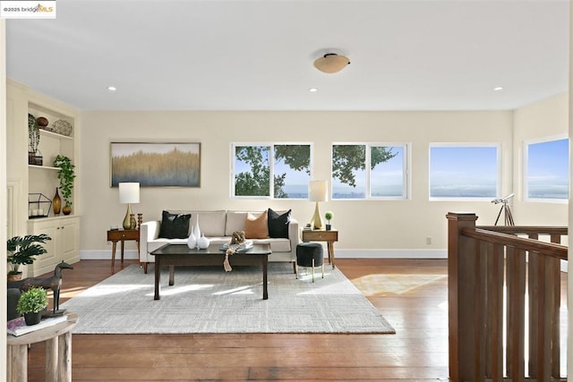 living room with built in features and light hardwood / wood-style floors