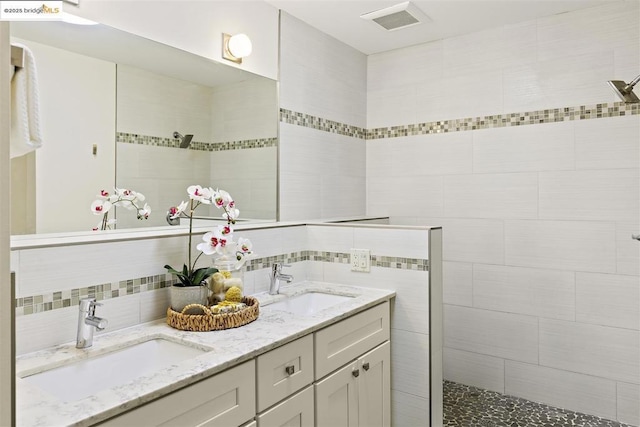 bathroom featuring backsplash, vanity, and a tile shower