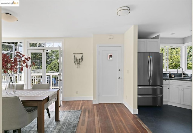 unfurnished dining area featuring sink, dark hardwood / wood-style floors, and plenty of natural light